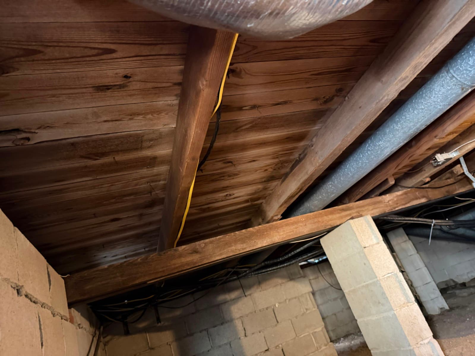 Mold staining across the exposed joist system and subfloor sheathing of a Fairfield, CT crawl space