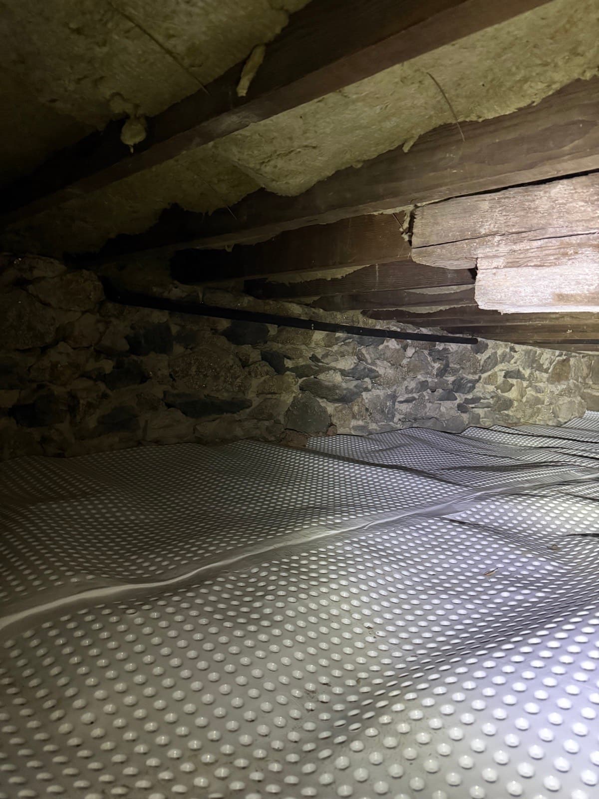 Dimple membrane installed against the fieldstone foundation of a Greenwich, CT sunroom crawl space