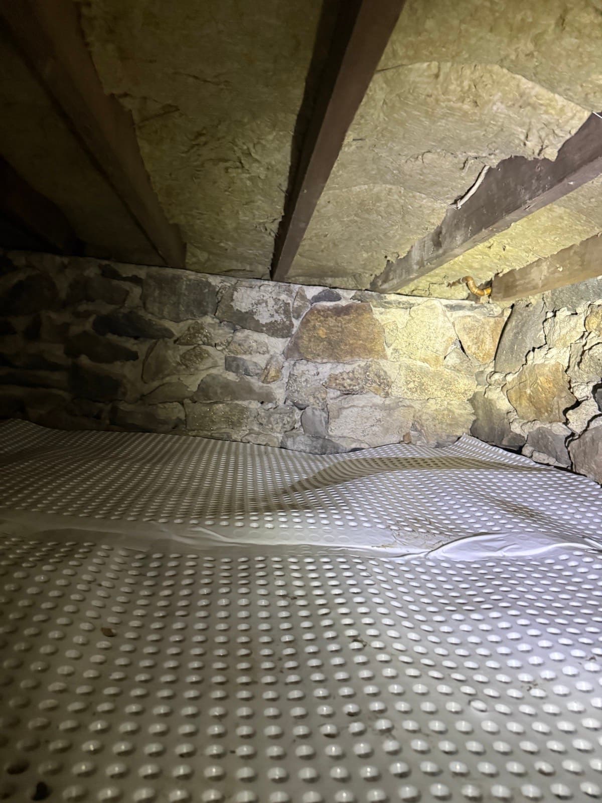Dimple membrane installed against the fieldstone foundation of a Greenwich, CT sunroom crawl space