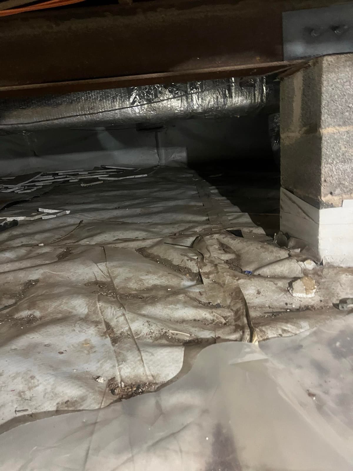 Failed vapor barrier and fallen insulation in a Norwalk, CT crawl space before cleanup