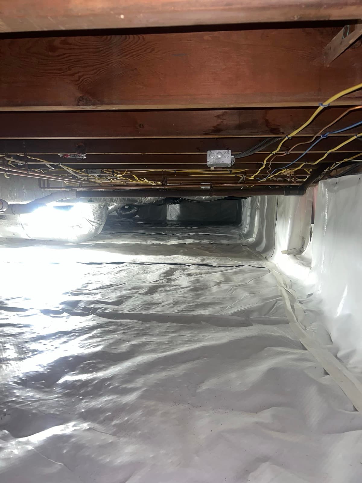 Failed vapor barrier and fallen insulation in a Norwalk, CT crawl space before cleanup