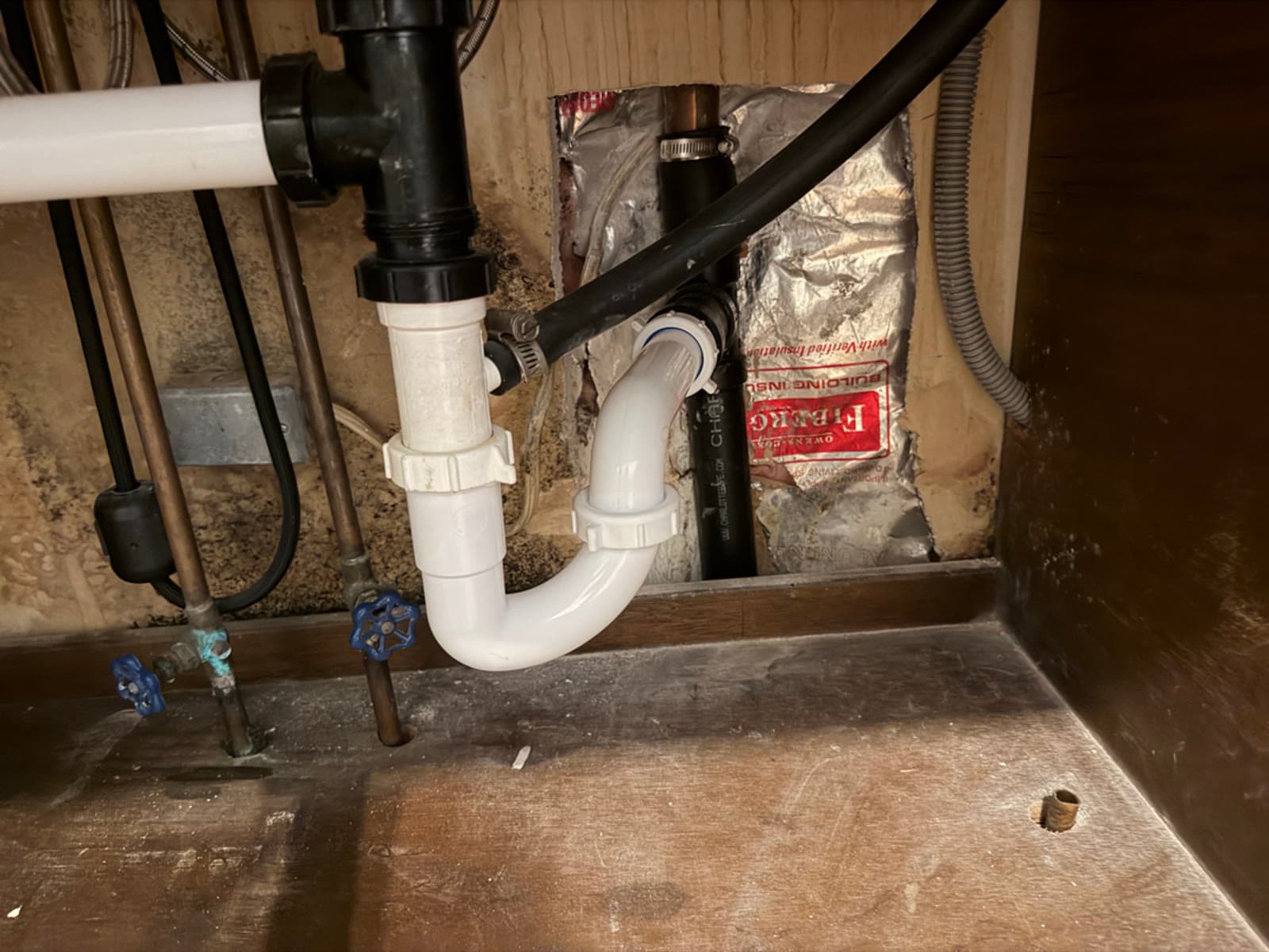 Water staining and damage under a kitchen sink cabinet in a Simsbury, CT home