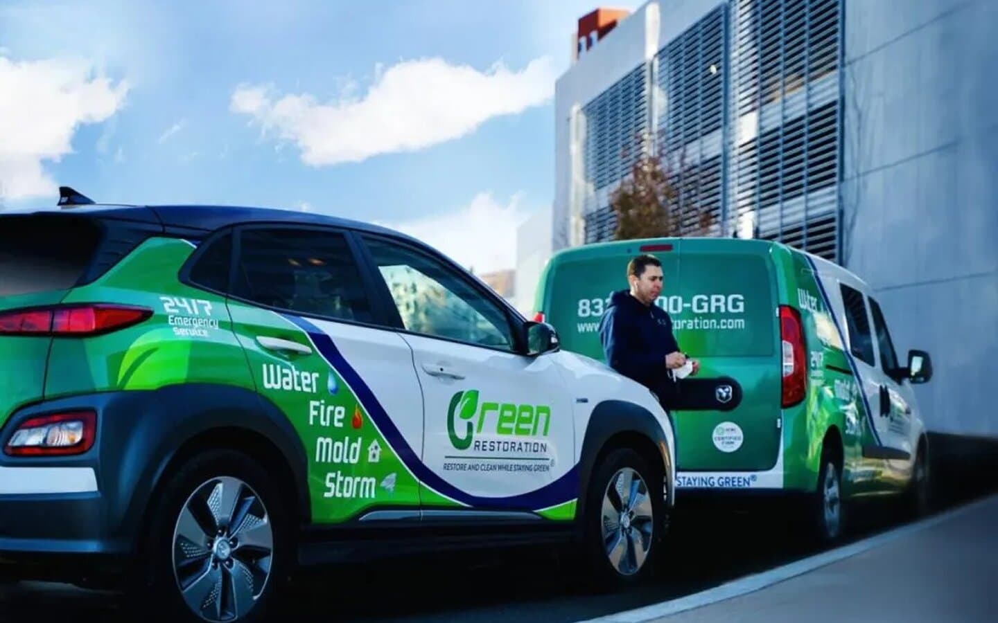 Green Restoration branded vehicles arriving at a commercial building