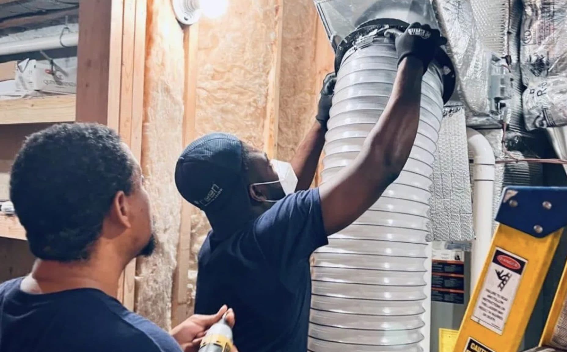 Green Restoration crew connecting source-removal cleaning equipment to a basement flex duct trunk during NADCA air duct cleaning at a Norwalk CT home
