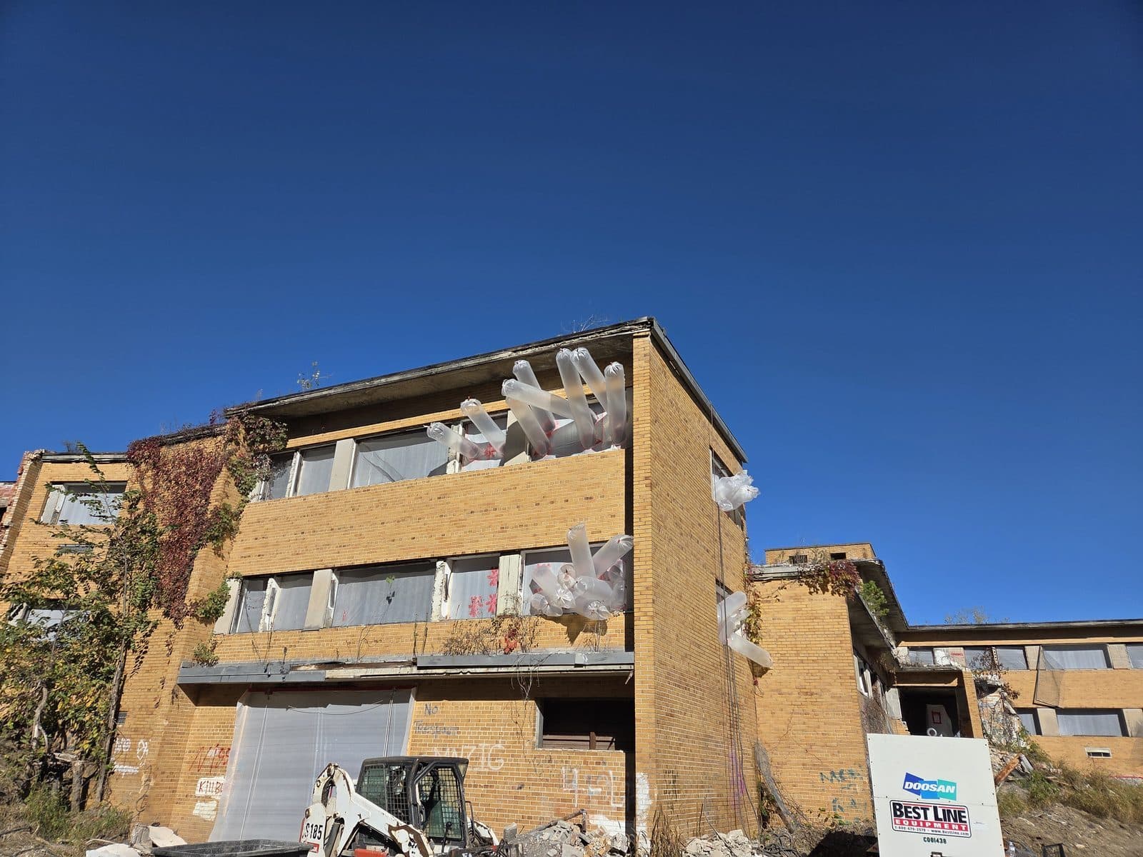 Exterior of a regulated asbestos abatement site with polyethylene containment and OSHA 1926.1101 work practice controls in place (Wikimedia Commons, CC0)