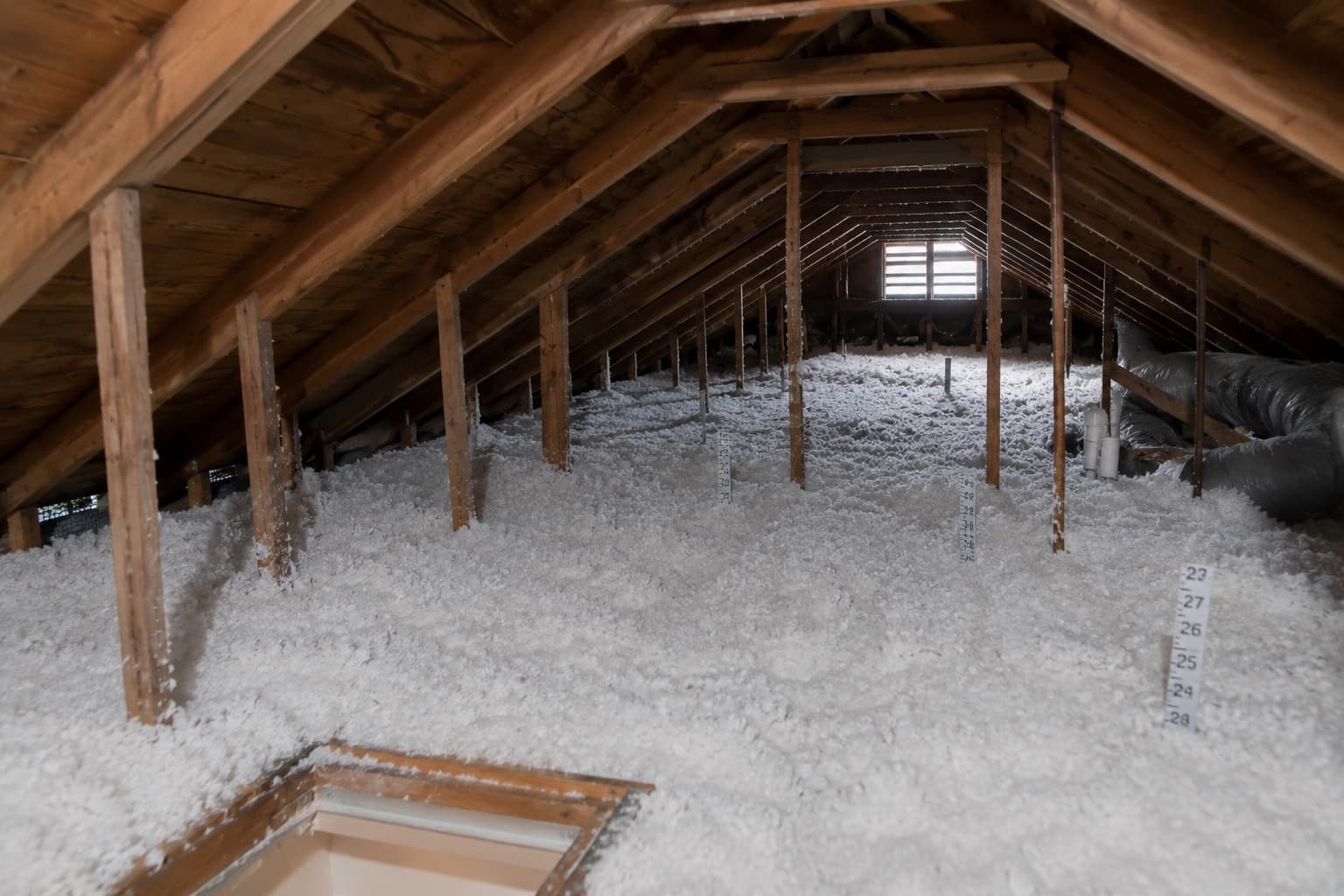 Residential attic after a Green Restoration project showing clean joist bays filled with new blown-in insulation to a deep R-value across Connecticut, New York, and Massachusetts