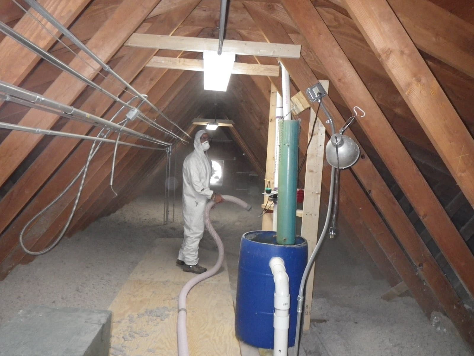 Green Restoration technician installing new blown-in insulation across a clean attic floor to a deep R-value during an attic project in the tri-state