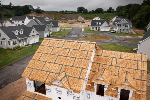 Documentary view of a residential construction site interior with drywall dust, paint tools, and debris visible during a Green Restoration pre-turnover walkthrough in the tri-state