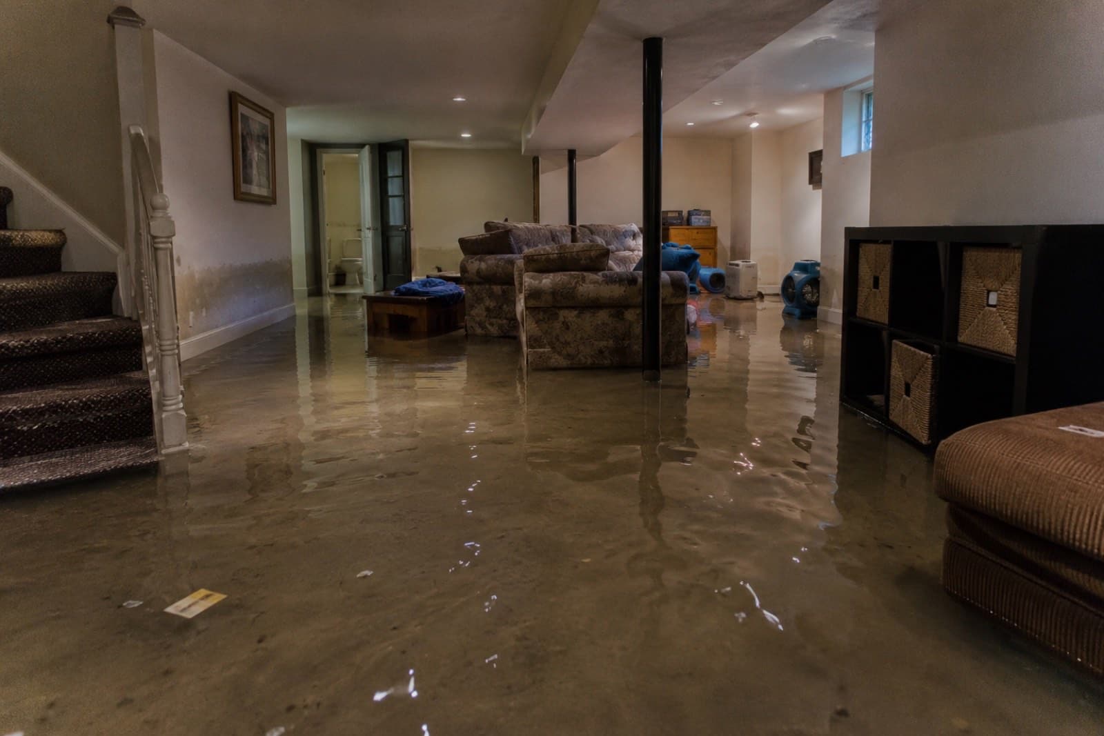 Finished basement with several inches of standing water during emergency water extraction in a Connecticut home