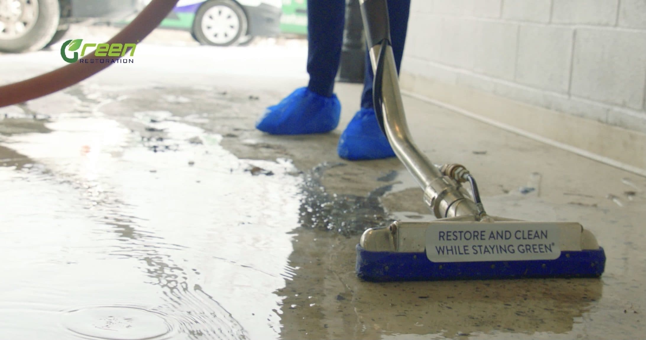 IICRC certified restoration technician operating a commercial LGR dehumidifier and air movers inside a residential room during active structural drying, with moisture meter in hand and daily log visible on a clipboard